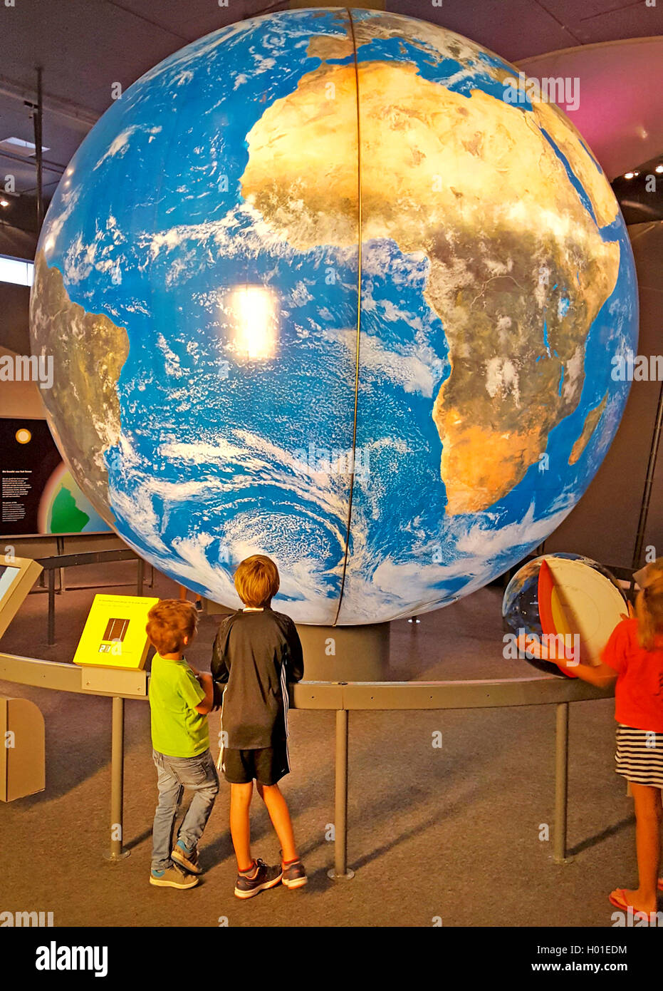 Deux enfants à la recherche d'un grand globe Banque D'Images