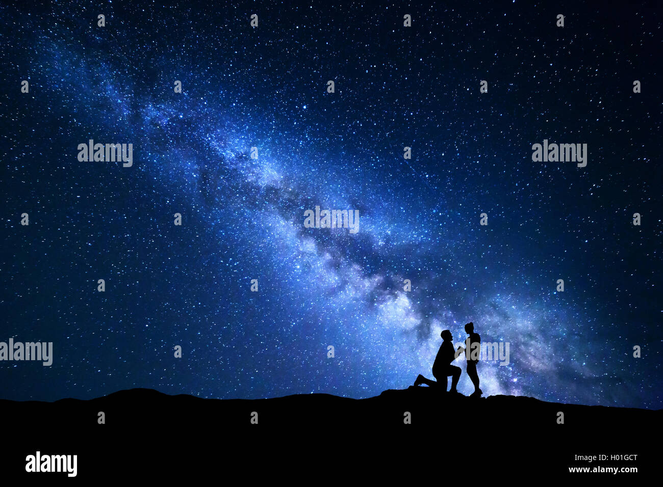 Voie lactée. Paysage de nuit avec des silhouettes d'un homme faire de demande en mariage à sa petite amie et ciel étoilé. Silhouette de lo Banque D'Images