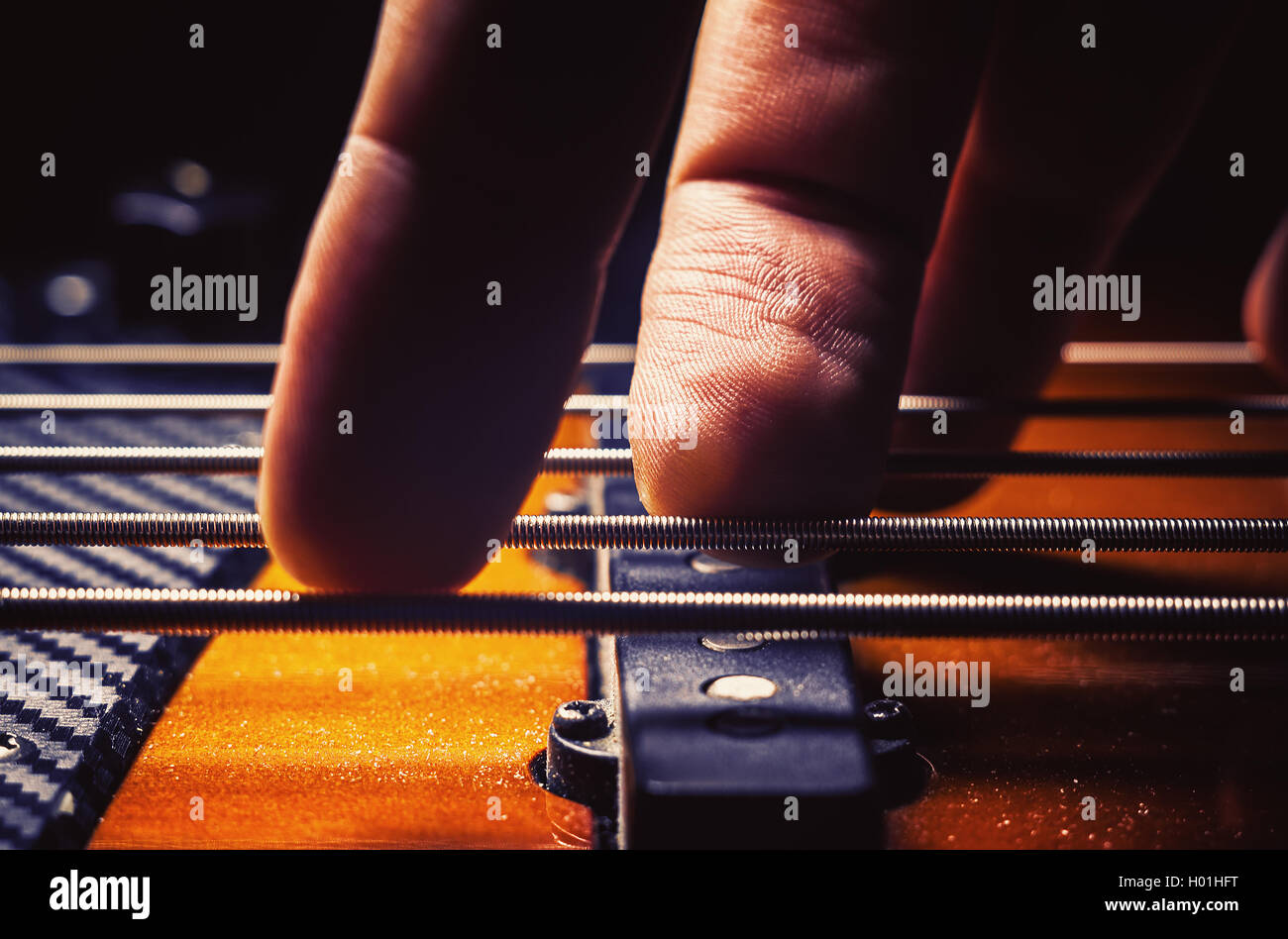 Les doigts masculins jouant cinq cordes guitare basse jazz. Banque D'Images