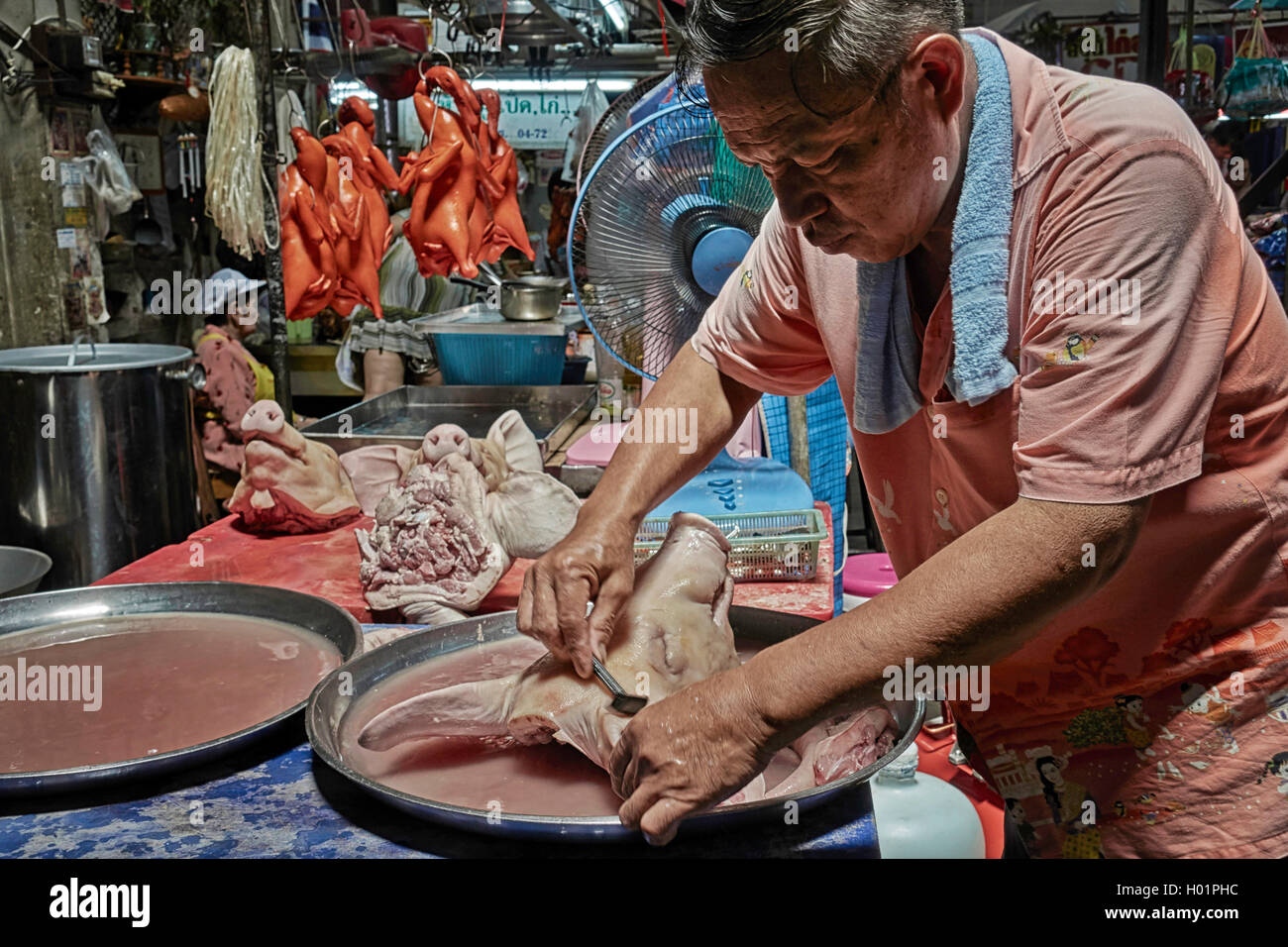 Le boucher thaïlandais se rasant le visage et la tête d'un porc pour être plus présentable à la vente sur son marché de décrochage. Thaïlande S. E. Asie Banque D'Images