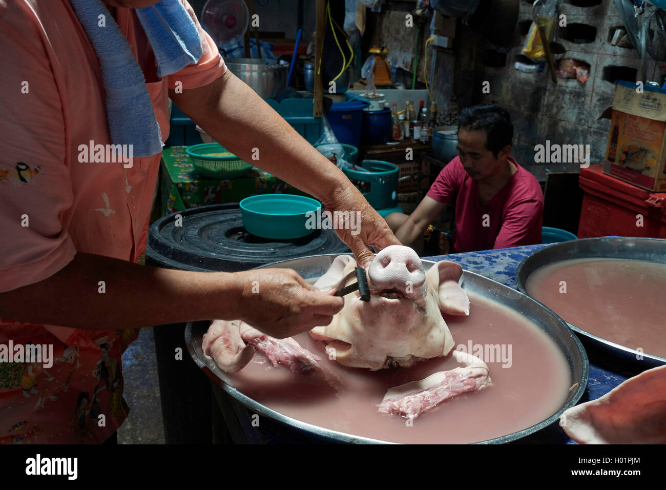 Le boucher thaïlandais se rasant le visage et la tête d'un porc pour être plus présentable à la vente sur son marché de décrochage. Thaïlande S. E. Asie Banque D'Images