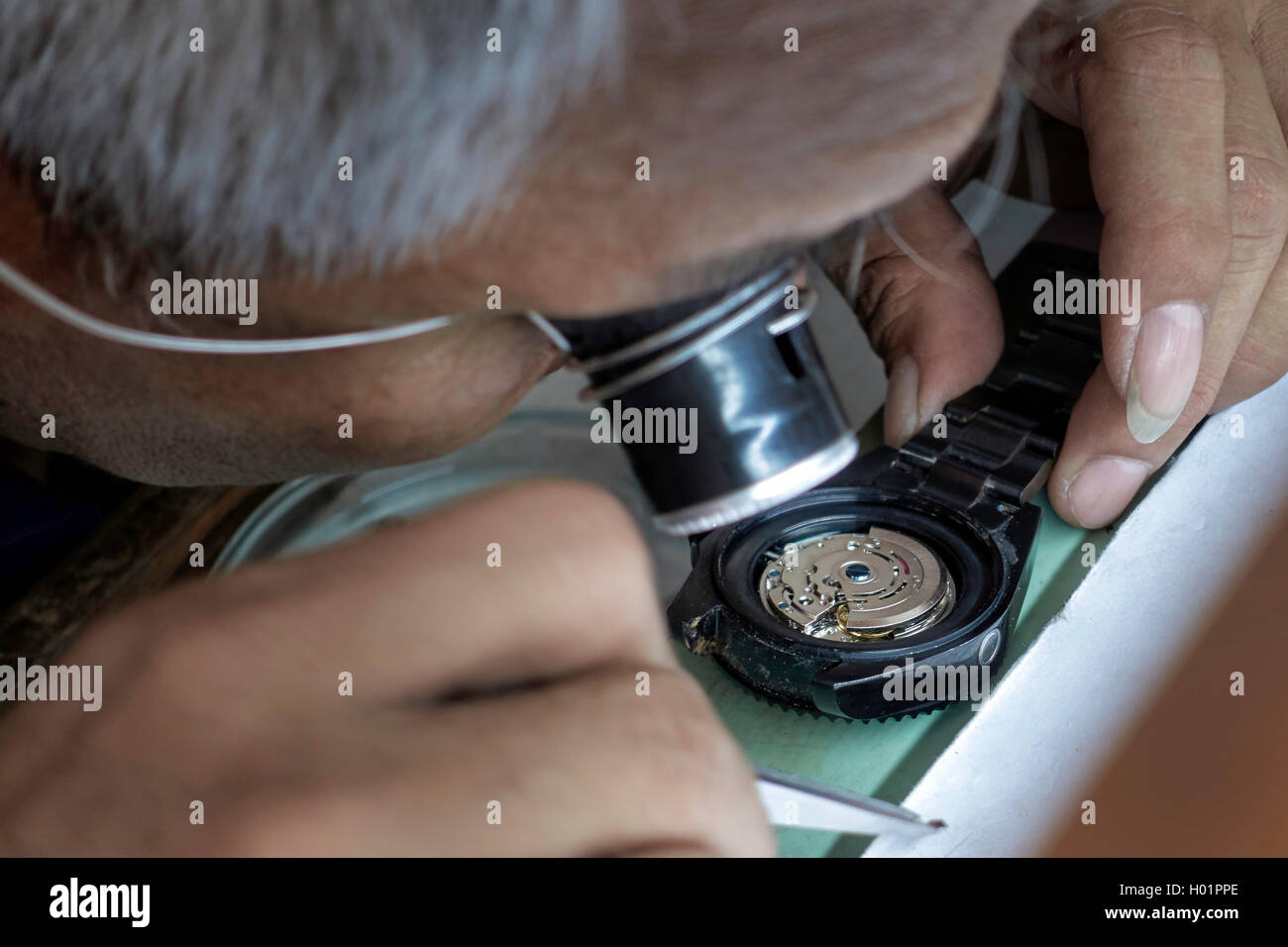 Gros plan d'un horloger au travail à l'aide d'une loupe. Banque D'Images