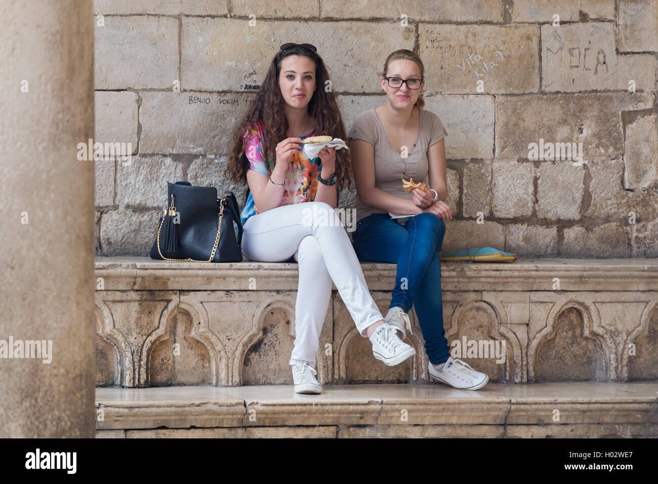 DUBROVNIK, Croatie - le 28 mai 2014 : young girls eating pizza cut en face de palais du recteur. Banque D'Images