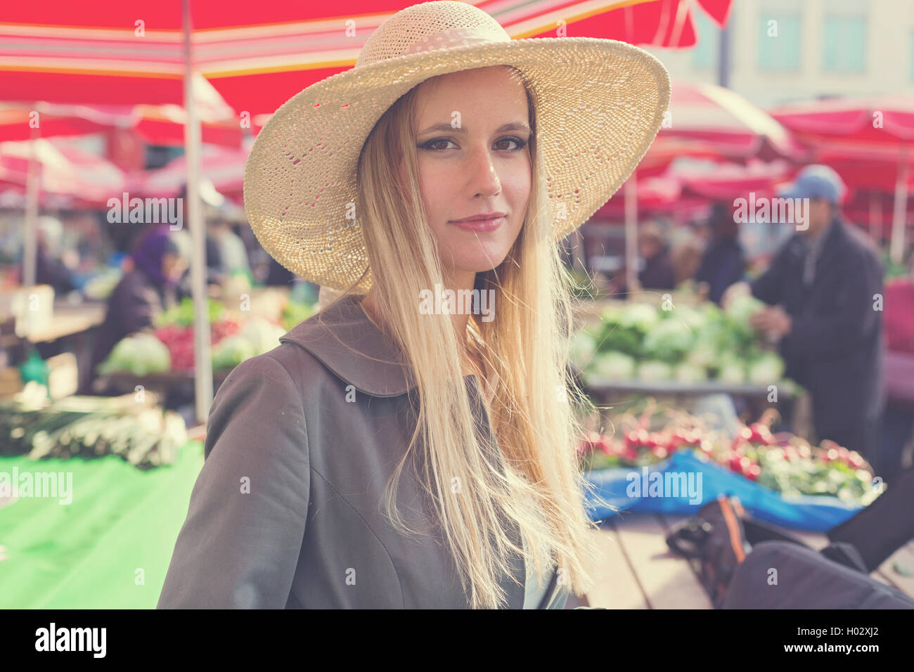 Portrait of attractive blonde fille avec chapeau de paille sur le marché. Poste a traité avec filtre vintage. Banque D'Images