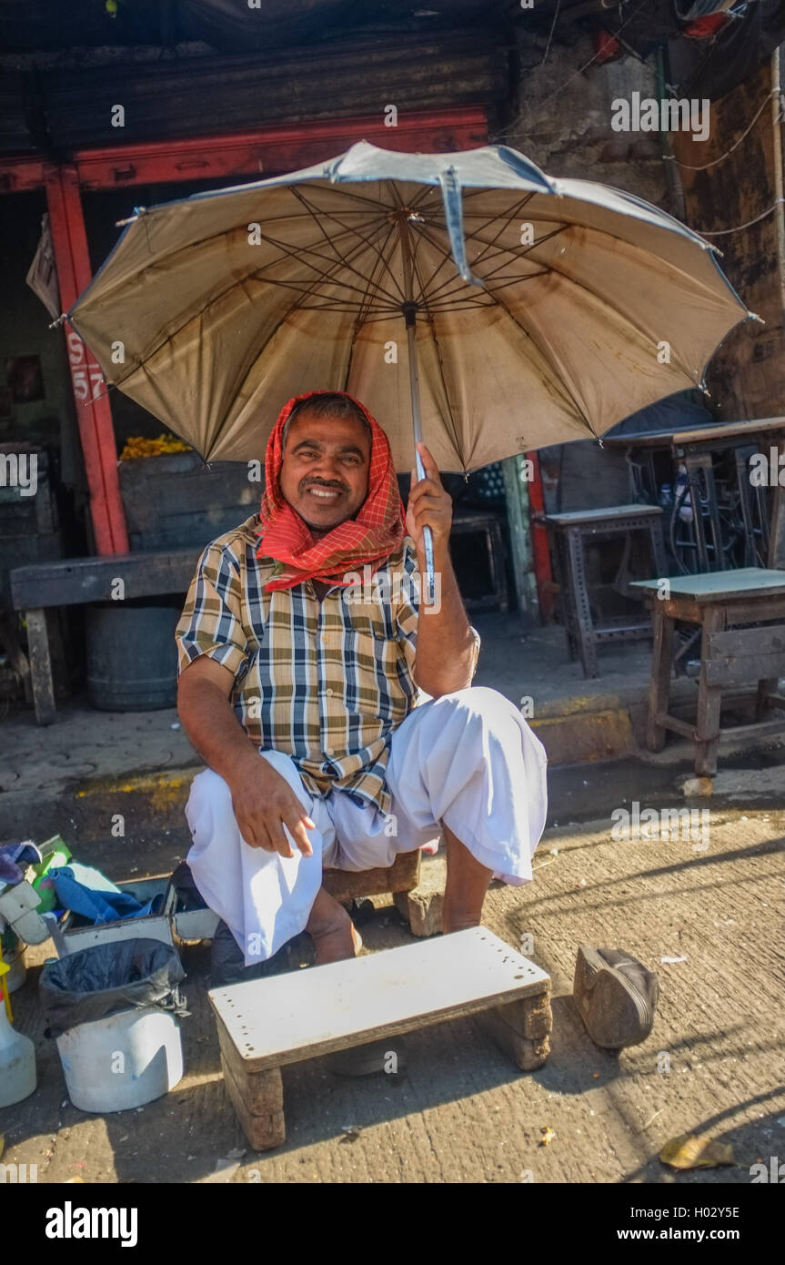 MUMBAI, INDE - 10 janvier 2015 : des travailleurs Indiens assis sous un parasol sur trottoir Banque D'Images