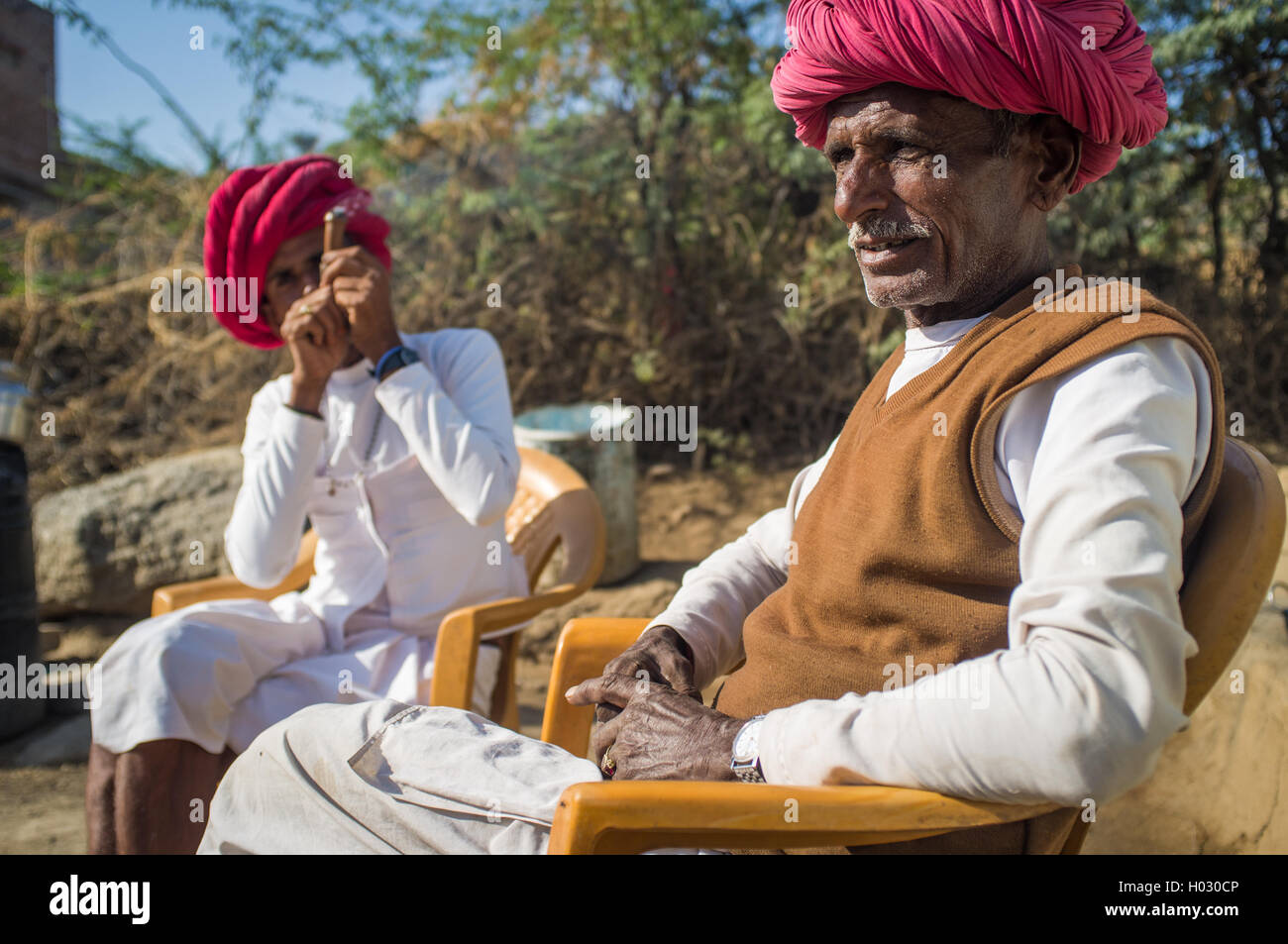 Région GODWAR, INDE - 13 février 2015 : personnes âgées Rabari tribesman siège avec voisin qui fume chillum. Rabari ou Rewari sont un Banque D'Images