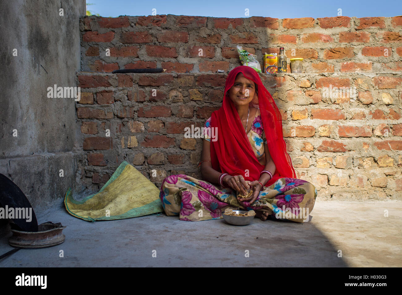 Région GODWAR, INDE - 13 février 2015 : femme indienne en sari est assis et mange chapati pour le petit-déjeuner. Banque D'Images