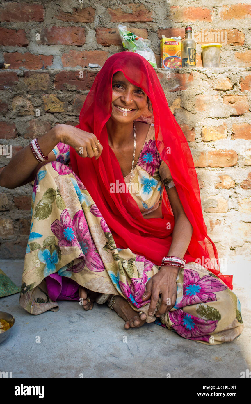 Région GODWAR, INDE - 13 février 2015 : femme indienne en sari est assis à côté de mur de briques. Banque D'Images