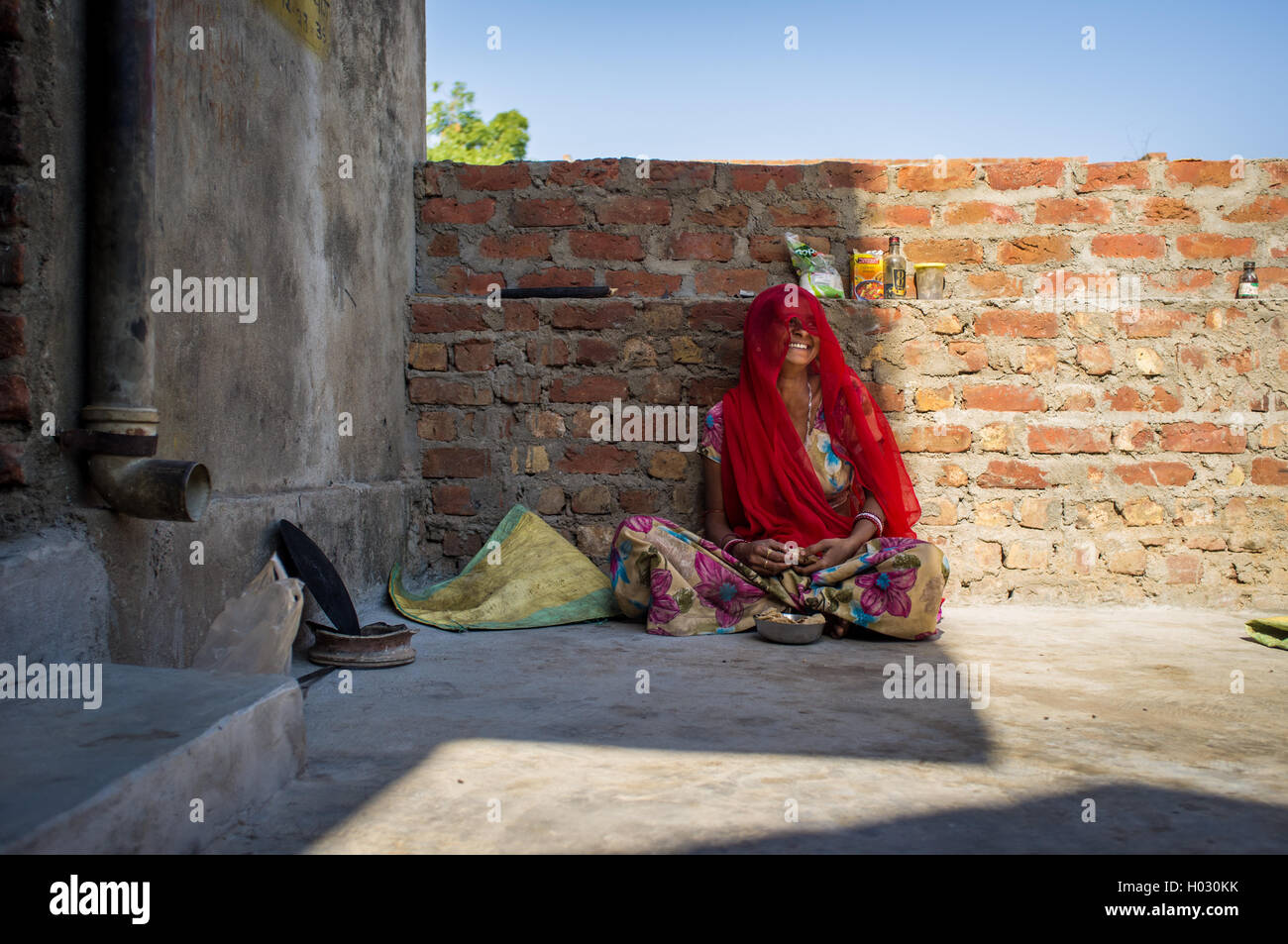 Région GODWAR, INDE - 13 février 2015 : femme indienne en sari est assis et rit en mangeant chapati pour le petit-déjeuner. Banque D'Images