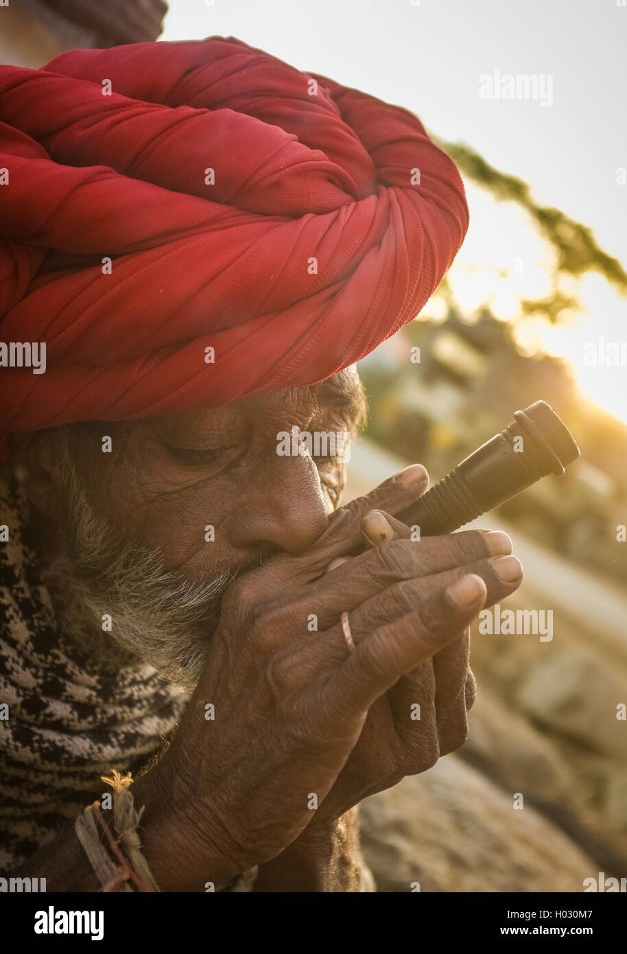 Région GODWAR, INDE - 14 février 2015 : personnes âgées Rabari tribesman avec turban rouge et une couverture fume chillum. Rabari Rewari ou un Banque D'Images