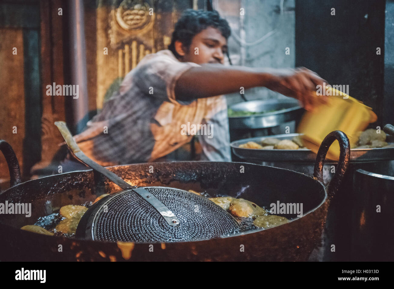 JODHPUR, INDE - 07 février 2015 : Jeune Indien vendeur de rue, de pommes de terre frites coupées en morceaux dans grande poêle. Motion Blur. Poster Banque D'Images