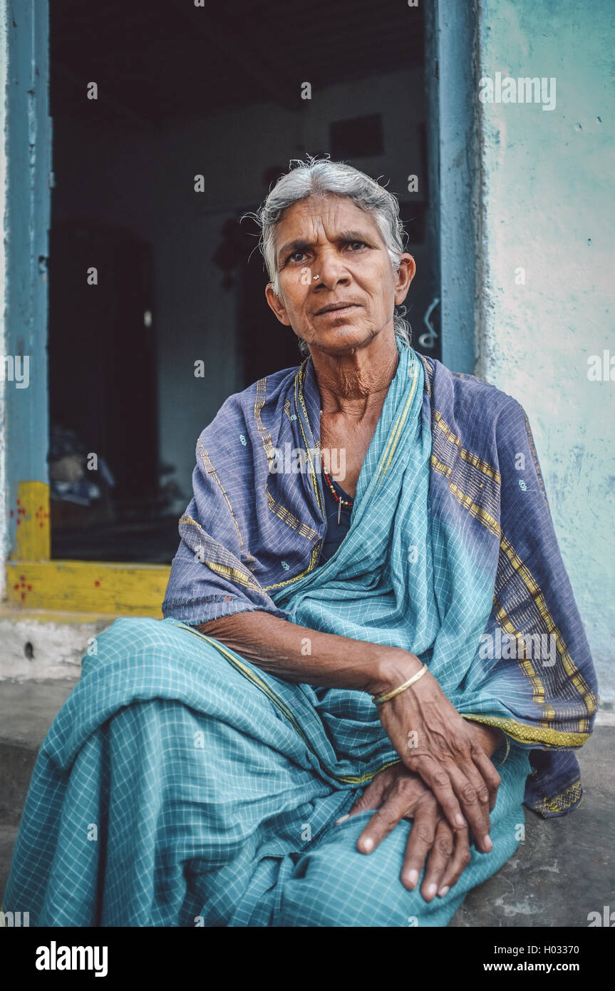 HAMPI, INDE - 31 janvier 2015 : personnes âgées femme indienne se trouve dans la région de sari en-face de la maison. Post-traités avec grain, texture et colou Banque D'Images