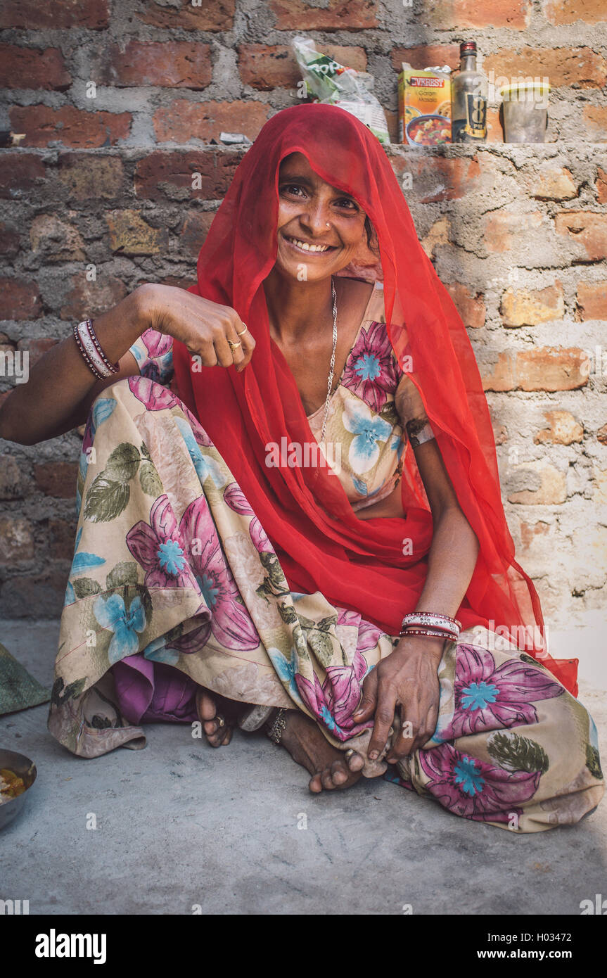 Région GODWAR, INDE - 13 février 2015 : femme indienne en sari est assis à côté de mur de briques. Post-traités avec grain, texture et co Banque D'Images
