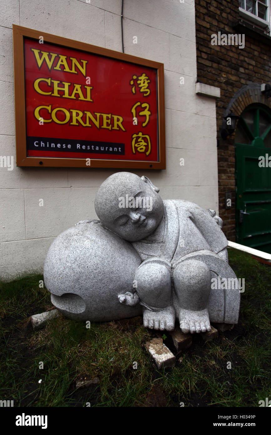 Sculpture d'un enfant endormi à Wan Chai Corner restaurant chinois, Gerrard Street, Londres, Royaume-Uni. Banque D'Images