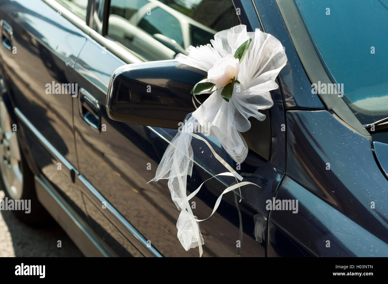 Des fleurs de mariage sur un miroir de voiture Banque D'Images