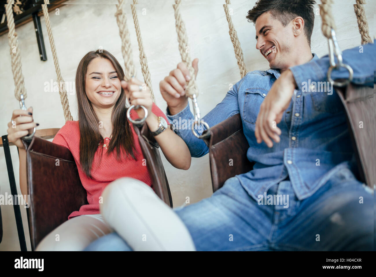Young couple relaxing in swing tout en parlant et le flirt Banque D'Images