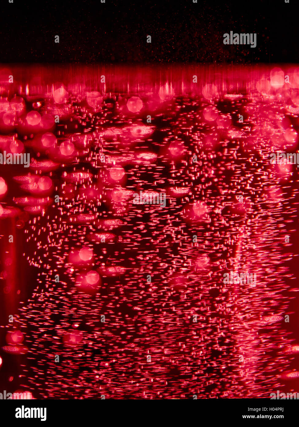 Résumé fond flou avec des bulles dans le liquide rouge Banque D'Images