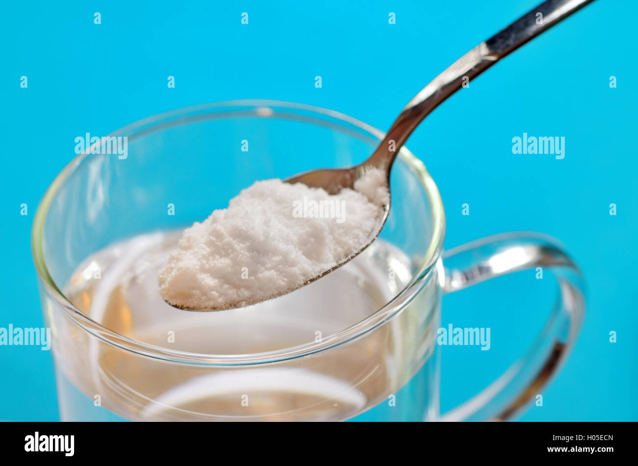 Cuillère à café de bicarbonate de soude sur du verre d'eau Photo Stock -  Alamy
