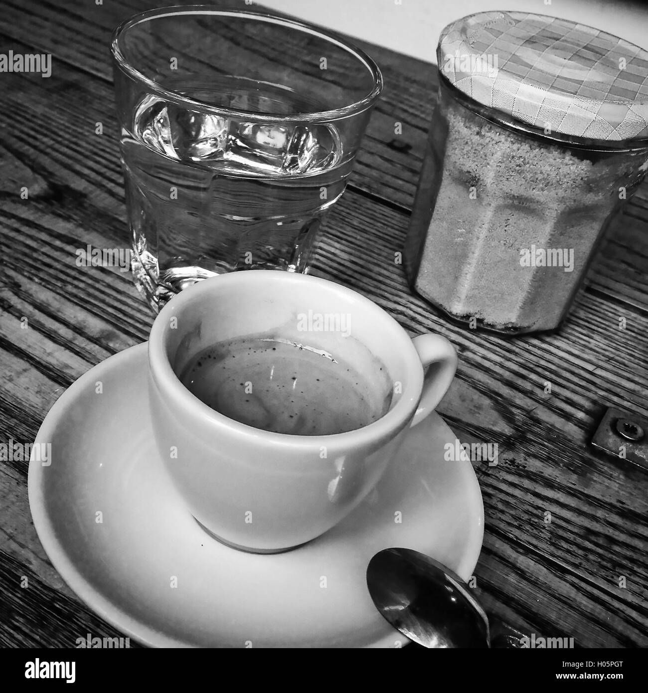 Tasse à espresso, verre d'eau et de sucre sur une table en bois Banque D'Images