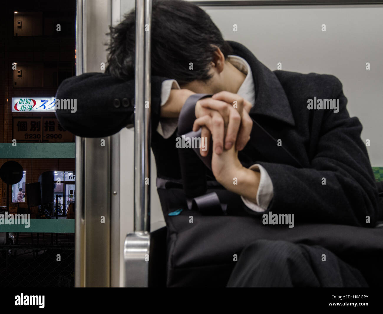 Les hommes dorment sur salaire fatigué du train de banlieue, Tokyo, Japon Banque D'Images