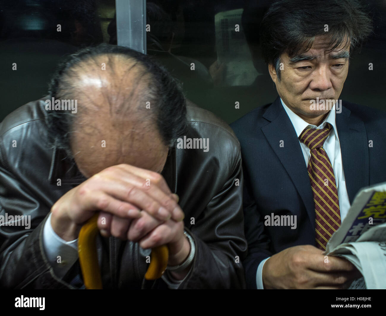Les hommes dorment sur salaire fatigué du train de banlieue, Tokyo, Japon Banque D'Images