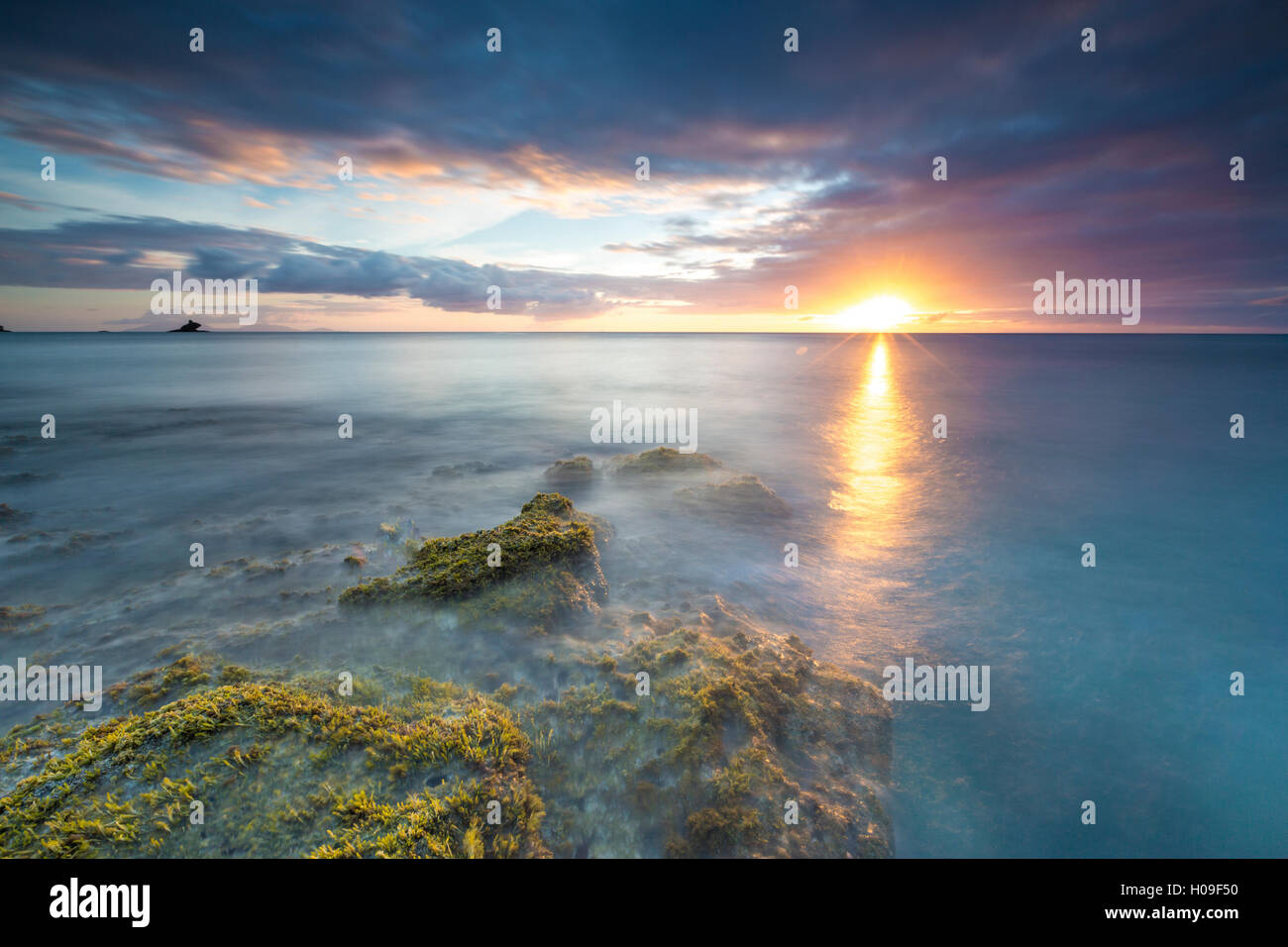 Les lumières de coucher du soleil se reflètent dans la mer bleue de la Baie d'Eretmochelys imbricata, Antigua, Antigua et Barbuda, Iles sous le vent, West Indies Banque D'Images