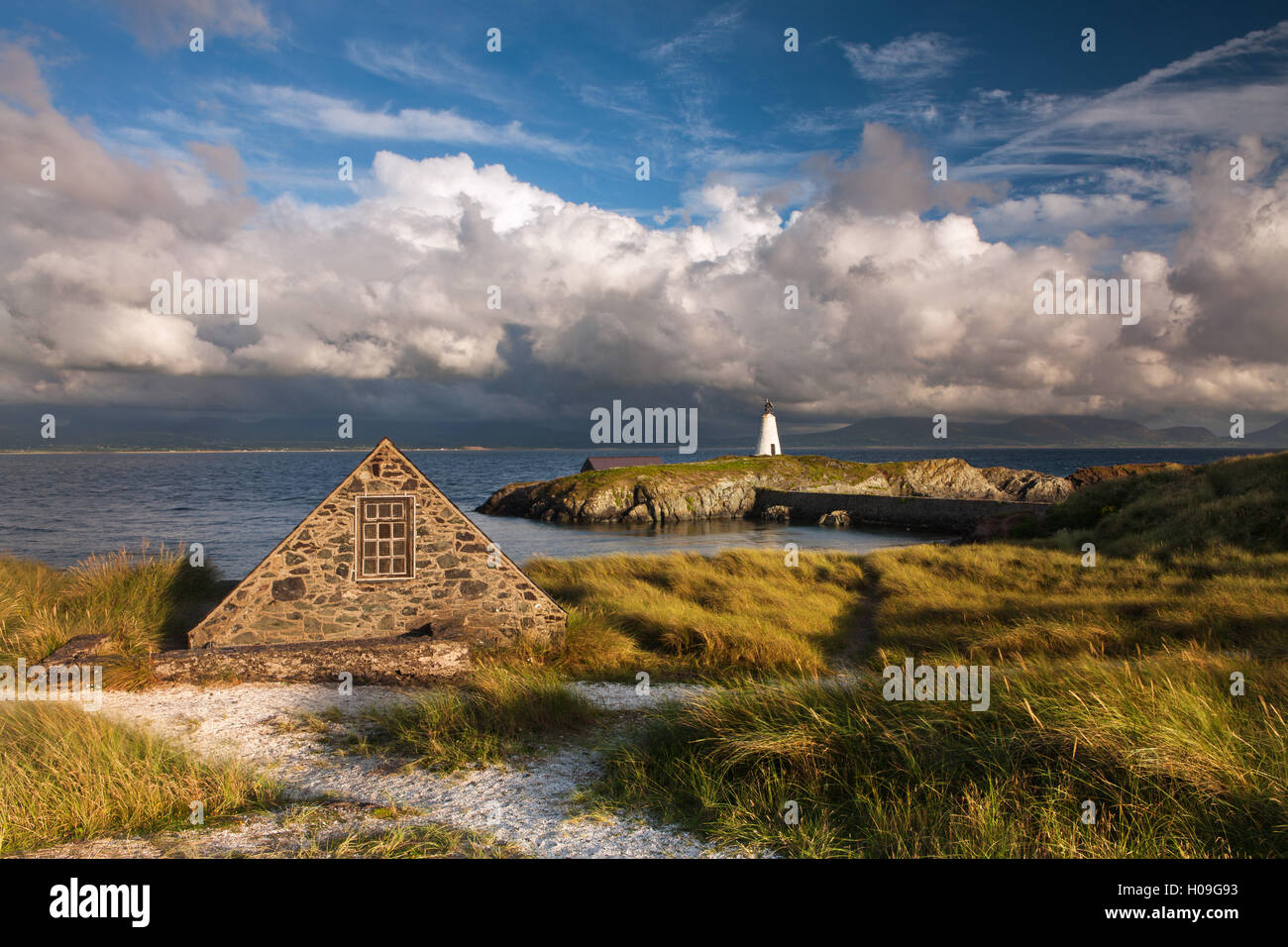 Un hangar à bateaux et Twr Mawr phare sur l'île Llanddwyn, Anglesey, Pays de Galles, Royaume-Uni, Europe Banque D'Images