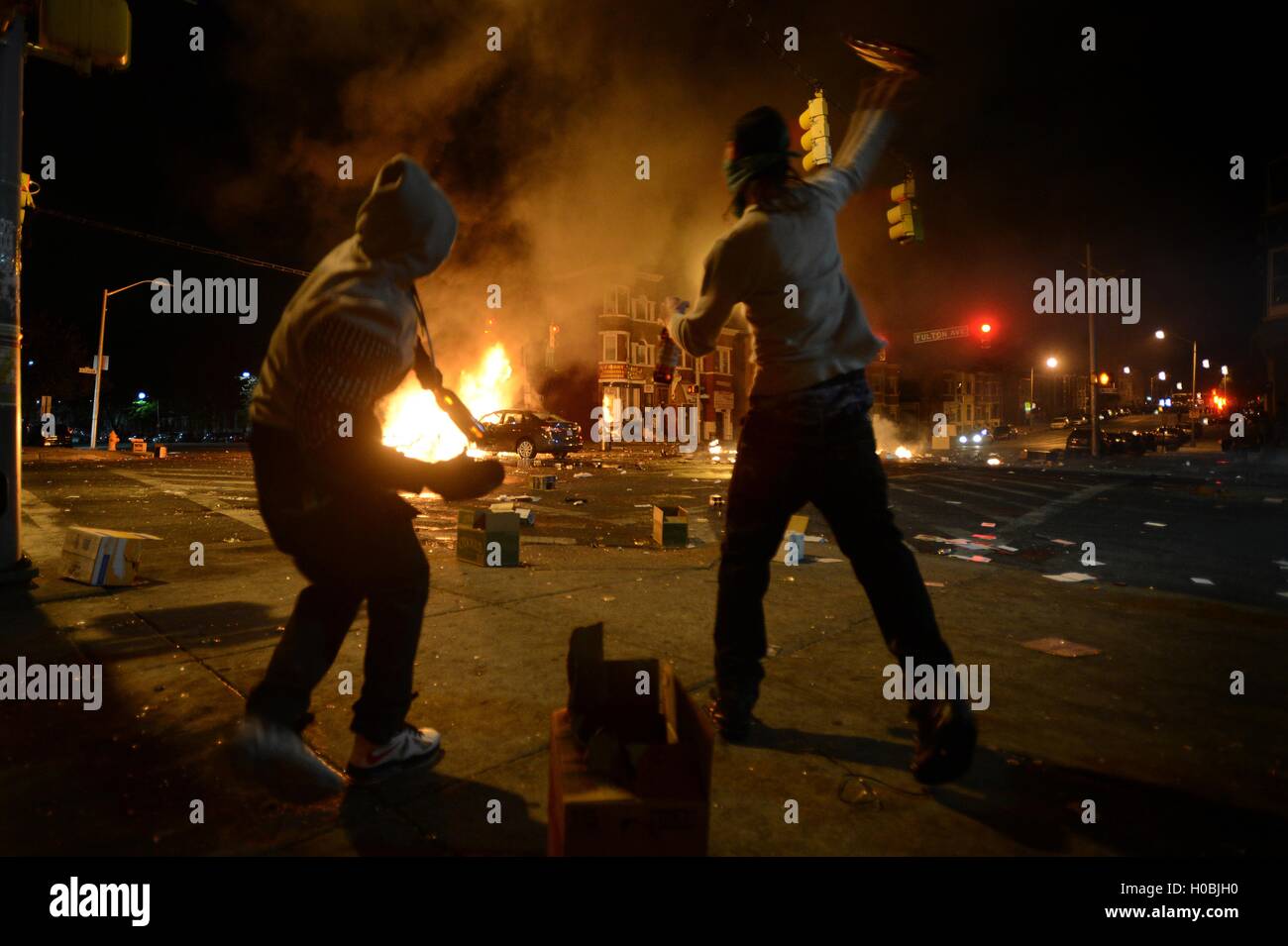 Deux hommes jeter des bouteilles de bière à des véhicules au cours des émeutes, à la suite des funérailles de Freddie Gray 27 avril 2015 à Baltimore, Maryland. Gray est décédé de blessures subies lors de sa garde à vue. Banque D'Images