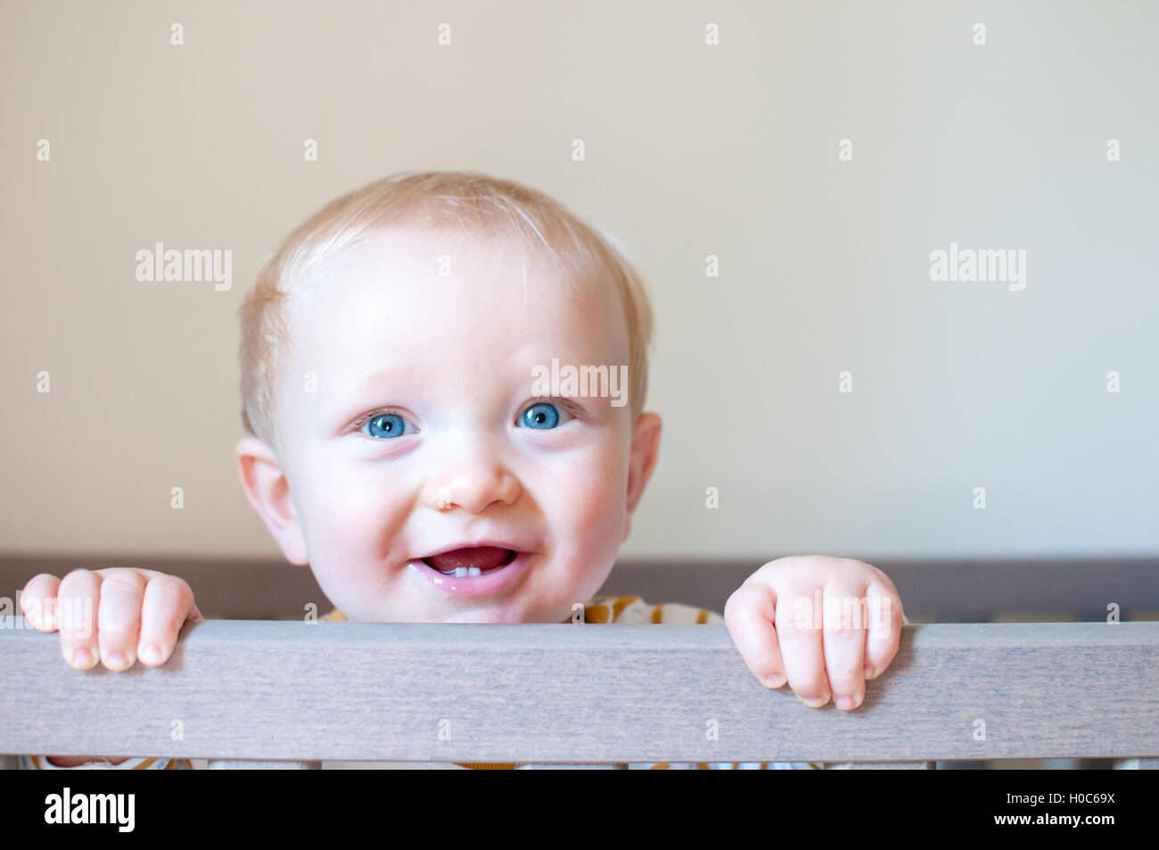 Bébé garçon sourire et rire sur un fond clair Banque D'Images