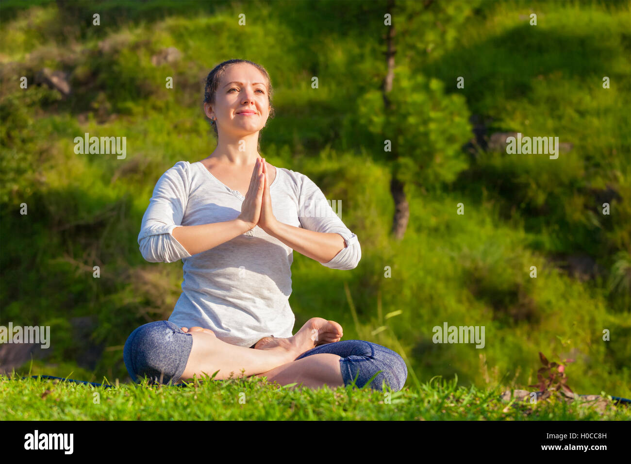Young fit woman doing yoga Lotus poser oudoors Banque D'Images