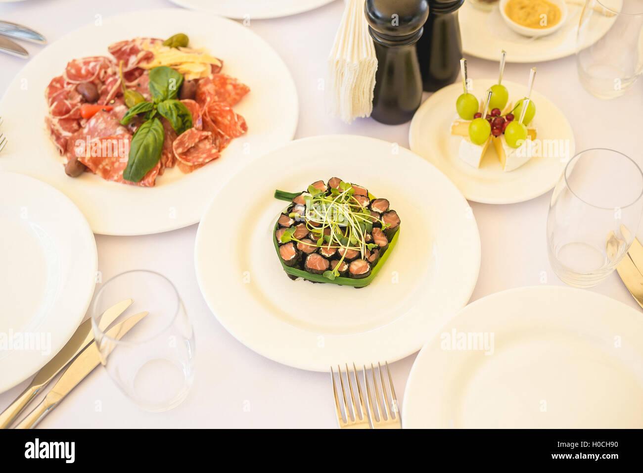 Table de banquet Restauration magnifiquement décorée avec des aliments différents en-cas et apéritifs avec caviar, sandwich, fruits frais sur le co Banque D'Images