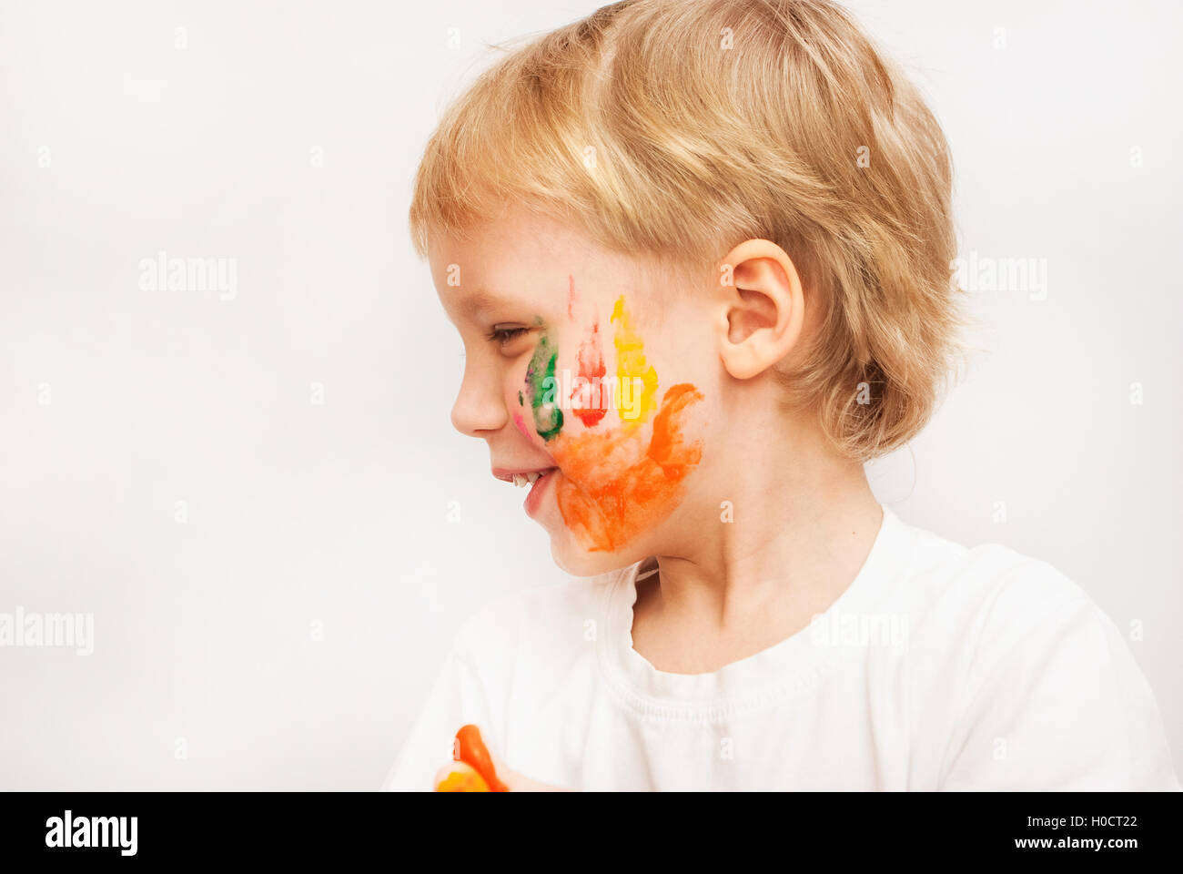 Petit garçon mains peints dans les peintures colorées Banque D'Images