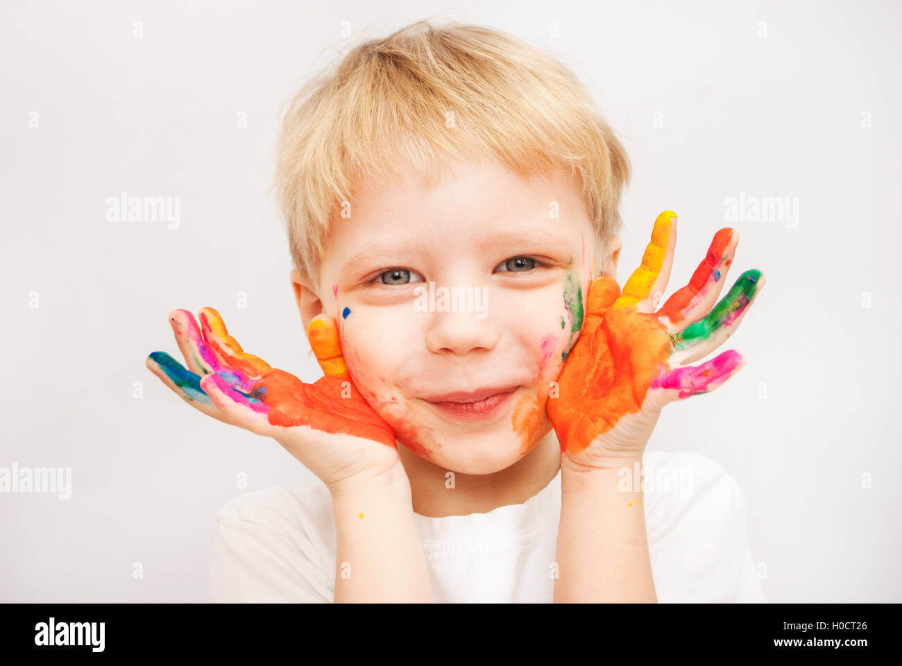 Petit garçon mains peints dans les peintures colorées Banque D'Images
