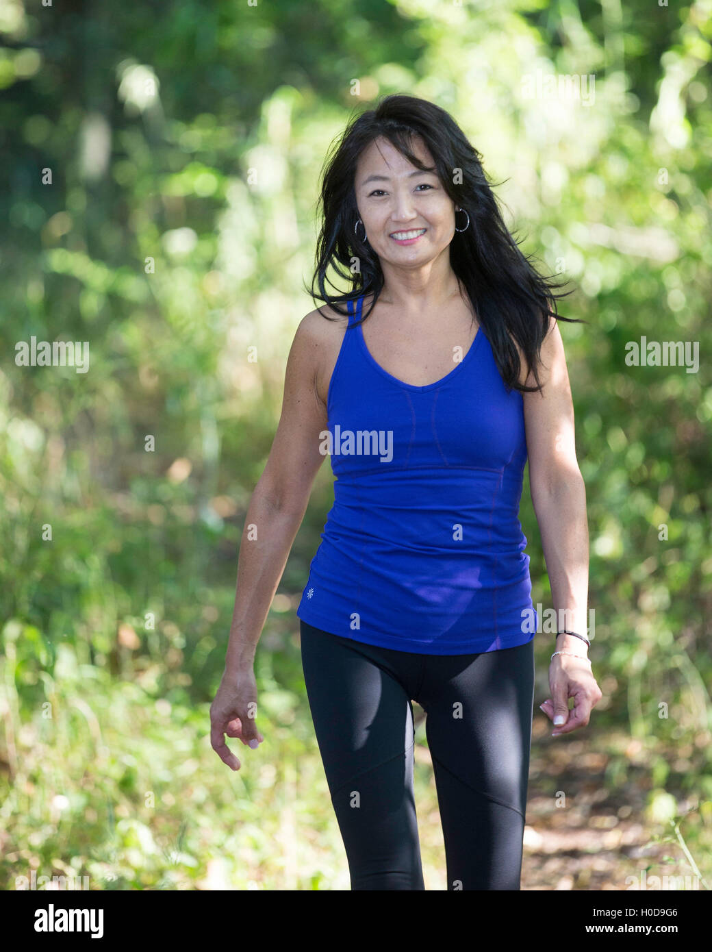 Asian American Woman walking in a park Banque D'Images