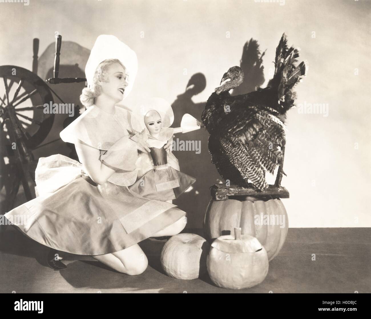 Woman holding doll portant le même costume Thanksgiving Banque D'Images