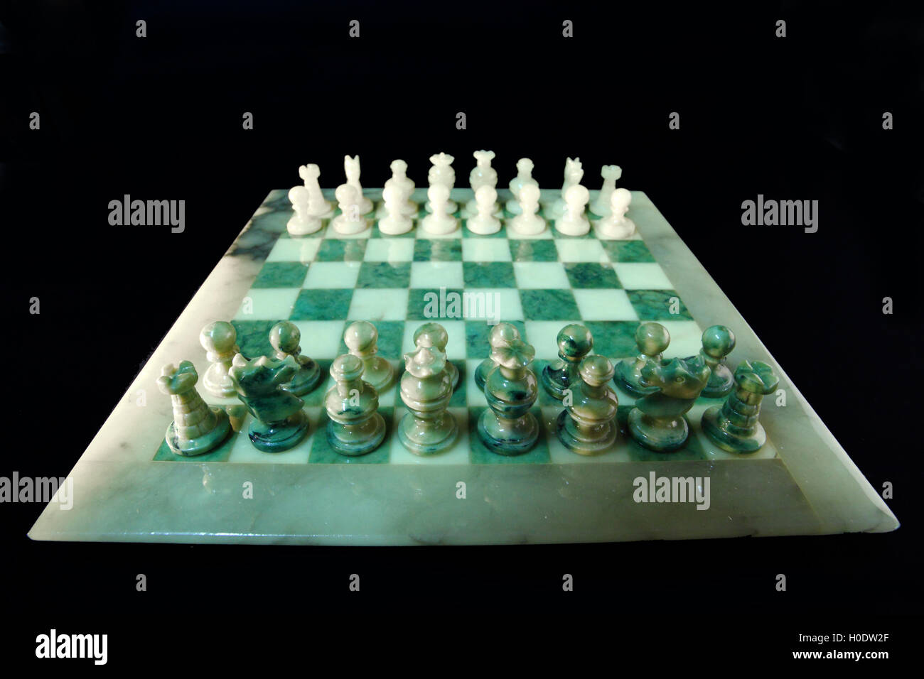 Échiquier et d'échecs d'albâtre sur un fond noir Banque D'Images