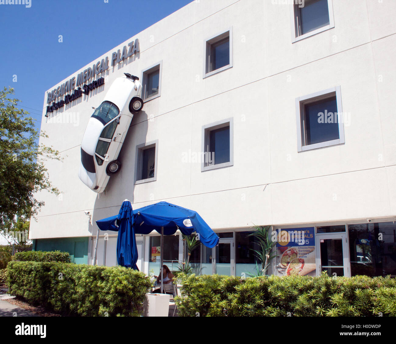 Une voiture de police montée de façon spectaculaire sur un mur à Miami, en Floride, se distingue comme une attraction insolite en bord de route et une exposition d'art urbain accrocheuse. Banque D'Images