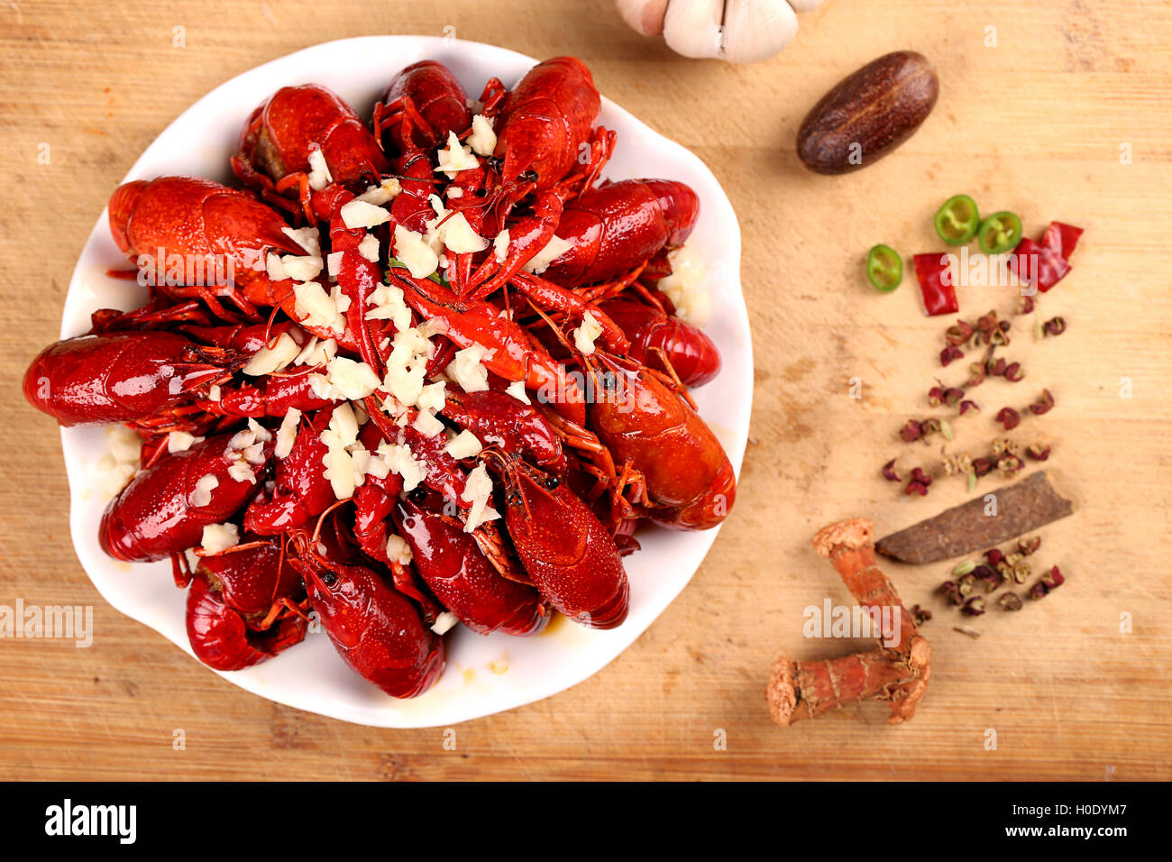 La langouste rouge ail sur plaque blanche avec des épices sur la table en bois Banque D'Images