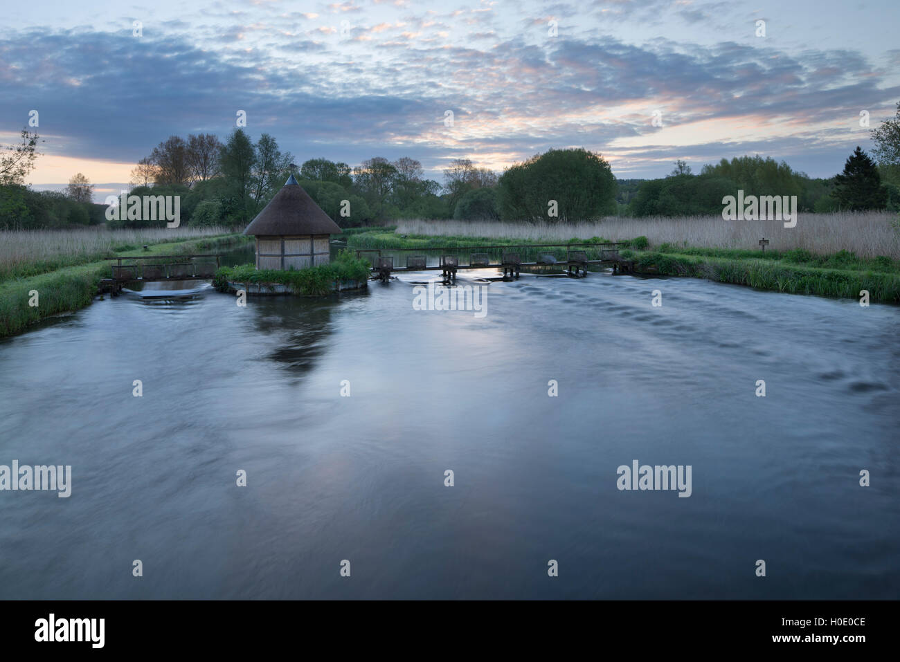 Cabane de pêcheur et les pièges de l'anguille enjambant la rivière Test à Longstock. Le Hampshire. L'Angleterre. UK. Banque D'Images