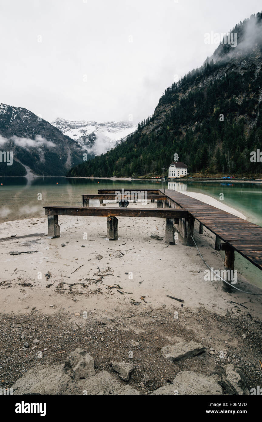 Jetée dans le lac Plansee situé dans l'Autriche un jour brumeux et nuageux. Composition verticale Banque D'Images