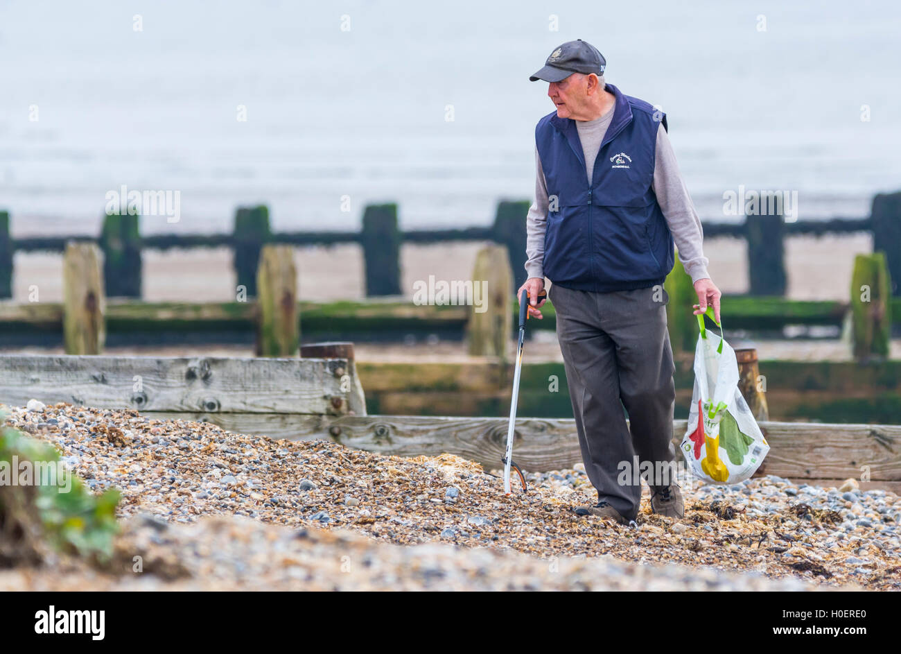 Homme âgé ramasser les déchets d'une plage. Banque D'Images