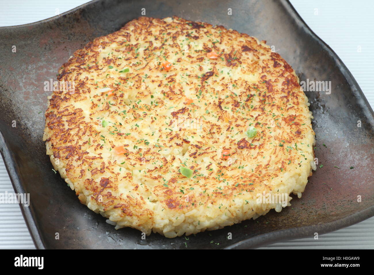 Risotto au fromage grillé ou crêpe de riz dans le style japonais sur plat noir Banque D'Images