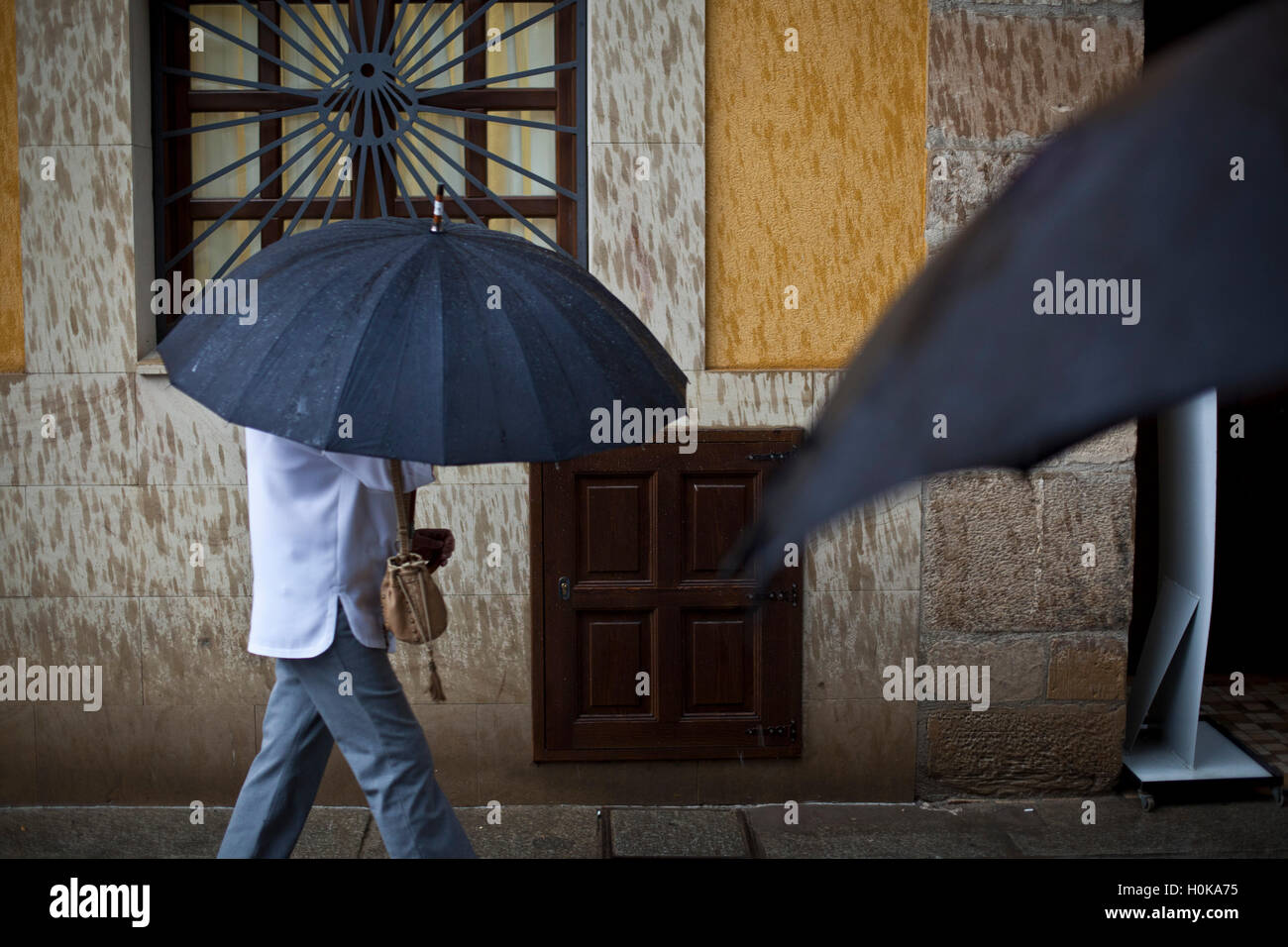 Deux noirs parapluies dans un Espagnol plaza Camino de Santiago, route Frances Banque D'Images