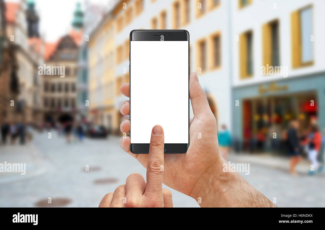 Smart phone dans l'homme de mains. Pour affichage isolé immersive. Rue de la ville en arrière-plan. Banque D'Images
