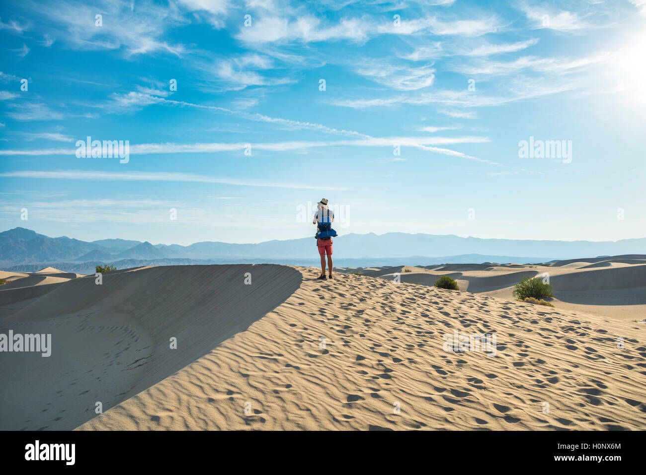 Young man photographing sand dunes, touristiques, de Mesquite Flat dunes de sable, contreforts de l'Amargosa Range derrière, la vallée de la mort Banque D'Images