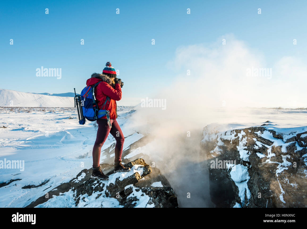 Femme debout à frontière tectonique divergente entre les plaques eurasienne et nord-américaine, à photographier, Mid-Atlantic Ridge Banque D'Images