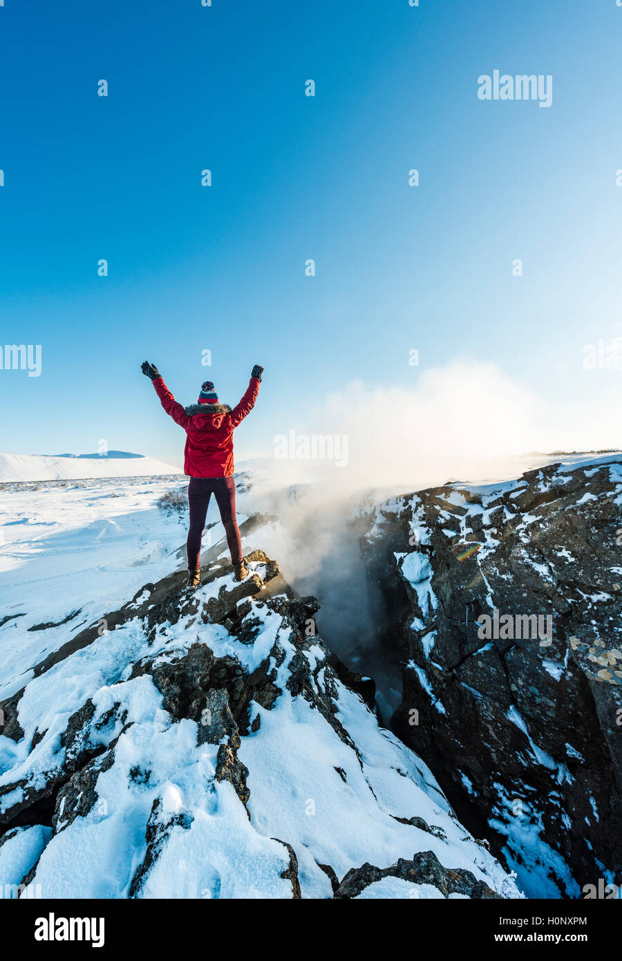 Femme debout à frontière tectonique divergente entre les plaques eurasienne et nord-américaine, les bras tendus, Mid-Atlantic Ridge Banque D'Images