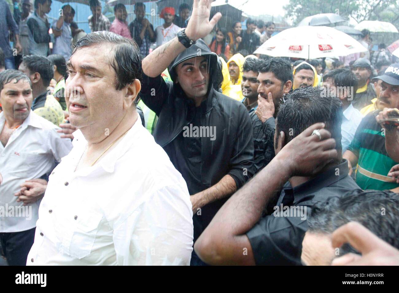 Bollywood acteur, Randhir Kapoor, Ranbir Kapoor, se tord en imperméable noir, se mouille en pluie mousson, participant à la procession du Ganesh Festival de R K Studio à Chembur, Mumbai, Inde Banque D'Images