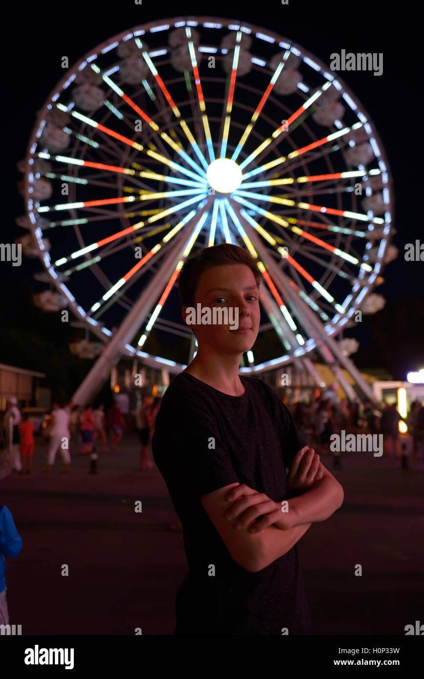 Teen boy in amusement park dans la nuit Banque D'Images