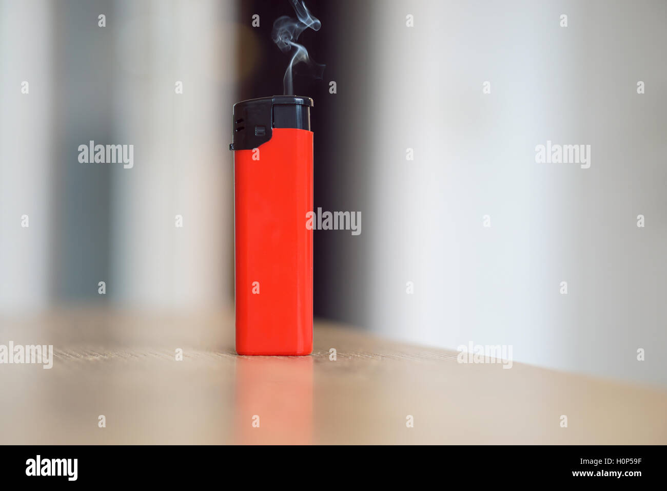 Briquet rouge avec un peu de fumée grise réel Banque D'Images